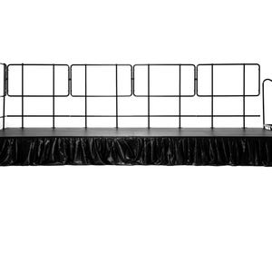 May include: Black stage with a black skirt and a black metal railing around the perimeter. The stage has a set of stairs on the right side.