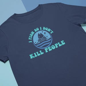 May include: A navy blue t-shirt with a light blue and green graphic that says "I fish so I don't kill people". The graphic features a cartoon fish in the water.