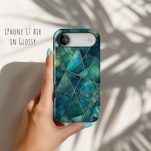 Op de afbeelding: Een glanzend telefoonhoesje voor een iPhone 17 Air met een geometrisch patroon van blauwgroene en donkergroene driehoeken gescheiden door dunne gouden lijnen. De tekst "iPhone 17 Air in Glossy" staat in de linkerbovenhoek van de afbeelding.