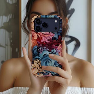 Puede incluir: Una funda para smartphone con un vibrante patr&oacute;n floral de remolinos en tonos rojo intenso, rosa suave, azul claro y crema. El dise&ntilde;o cubre toda la parte posterior de la funda, que tiene un recorte rectangular en la parte superior para la c&aacute;mara.