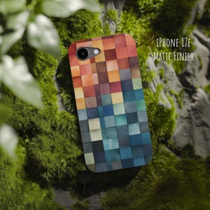 May include: A phone case for an iPhone 17E with a matte finish, featuring a grid pattern of square tiles in a gradient of colors transitioning from warm orange and red tones at the top to cool blue and dark grey shades at the bottom.