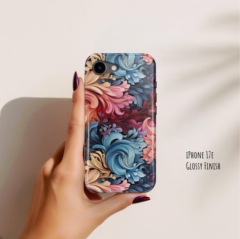 Puede incluir: Una funda para tel&eacute;fono con acabado brillante que presenta un patr&oacute;n floral vibrante y arremolinado en tonos azul, rosa y crema. La funda est&aacute; etiquetada como iPhone 17E Glossy Finish. El dise&ntilde;o consta de motivos bot&aacute;nicos complejos.