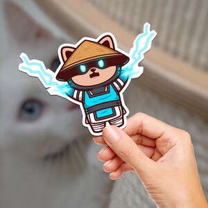May include: A cartoon sticker of a brown and white panda wearing a blue and white outfit and a brown hat. The panda is surrounded by blue lightning bolts.