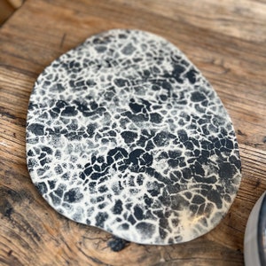 Onderzetter van zwart en wit gemarmerd steengoed, 30 cm