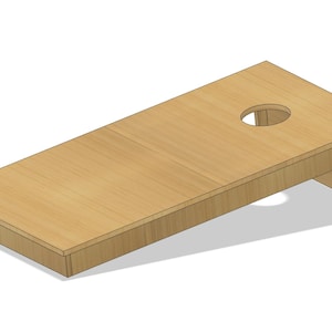 Puede incluir: Una tabla de cornhole de madera de color marrón claro. La tabla tiene un agujero circular cerca de la parte superior y está sostenida por patas anguladas. Ideal para juegos al aire libre.