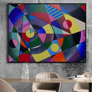Puede incluir: Pintura geométrica abstracta enmarcada en negro. La obra presenta una vibrante composición de formas, incluyendo círculos, triángulos y rectángulos, en una variedad de colores como azul, rojo, amarillo y verde. La pintura se exhibe en una pared gris.
