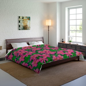 May include: A pink and green floral duvet cover with a tropical print featuring large pink flowers and green leaves.