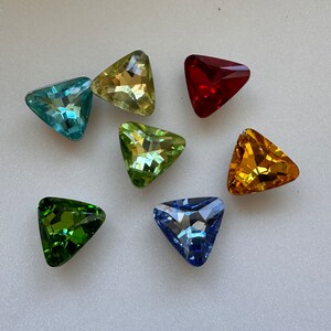 May include: Seven triangular faceted glass gems in various colours: light blue, green, yellow, red, dark blue, light green, and orange.