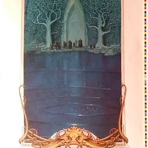 May include: A vintage poster featuring a fantasy illustration of a dark, mysterious gate guarded by a monstrous creature. The gate is framed by two trees with bare branches and is surrounded by a pool of water. The text "The Watcher at the Gate - by Steve Hickman" is at the bottom of the poster.
