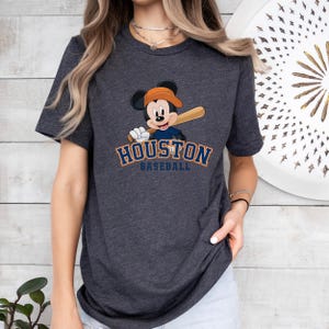a woman wearing a houston baseball mickey mouse t - shirt