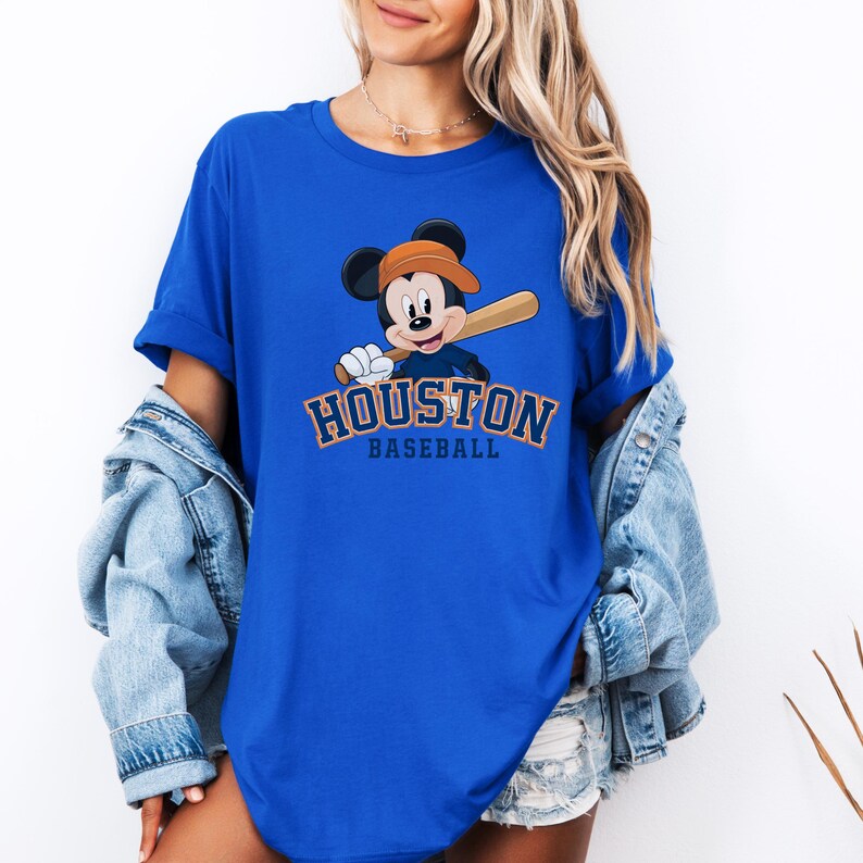 a woman wearing a blue shirt with a mickey mouse on it