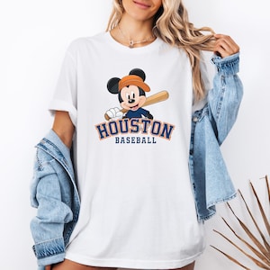 a woman wearing a houston baseball mickey mouse t - shirt