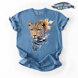 A blue t-shirt with a close-up image of a leopard's face printed on it.