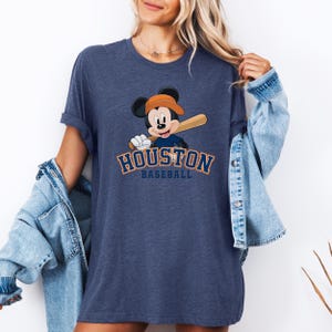 a woman wearing a blue shirt with a mickey mouse on it