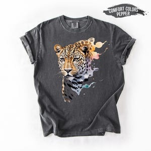 a gray t-shirt with a vibrant graphic of a leopard's face, showcasing its distinctive features such as its eyes, nose, and mouth.
