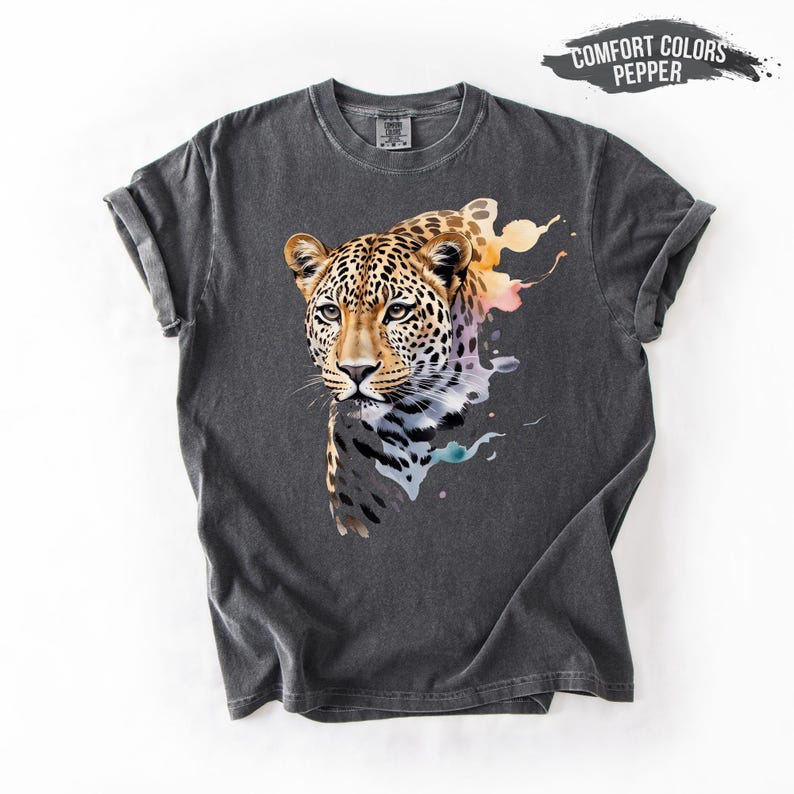 a gray t-shirt with a vibrant graphic of a leopard's face, showcasing its distinctive features such as its eyes, nose, and mouth.