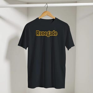 May include: A black short-sleeved t-shirt featuring the word Renegade printed in bold yellow letters across the chest. The garment is displayed on a wooden hanger against a plain white background, showcasing a simple crew neck design.