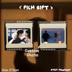 Könnte beinhalten: Zwei individuelle Foto-Filmgeschenke, jeweils 5 x 5 cm, mit beigem Rand und schwarzen Akzenten. Eines zeigt ein küssendes Paar, das andere ein Paar, das sich am Strand an den Händen hält. Text: "< FILM GIFT >" und "Custom Photo."