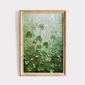 Op de afbeelding: Een schilderij van een veld met groene vierbladige klavers in een houten lijst. De klavers zijn geschilderd in een textuurrijke stijl, waardoor het schilderij een driedimensionale uitstraling krijgt.