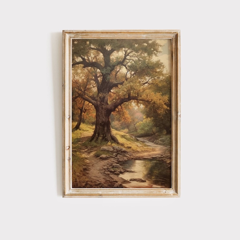 May include: A framed painting of a forest scene with a large oak tree in the center. The tree has a thick trunk and branches that reach out towards the sky. The forest floor is covered in fallen leaves and there is a small stream running through the scene.