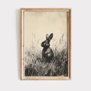 May include: A black and white illustration of a rabbit sitting in a field of tall grass. The rabbit is looking to the right, and the background is a light beige color.