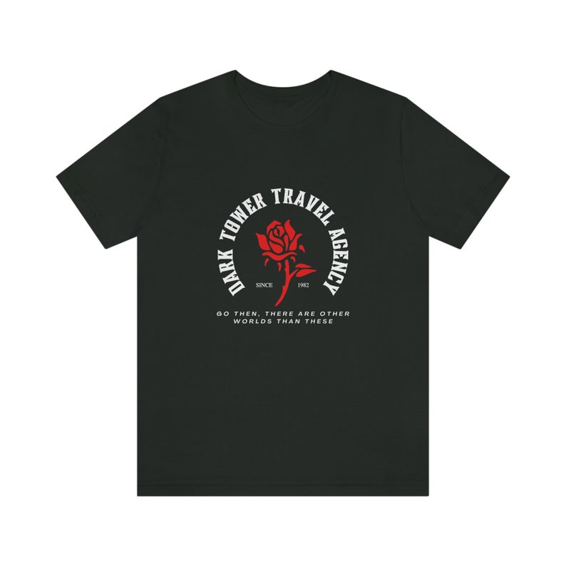 Puede incluir: Camiseta negra con un gr&aacute;fico circular blanco que presenta una rosa roja y el texto "Dark Tower Travel Agency Since 1982" y "Go then, there are other worlds than these."