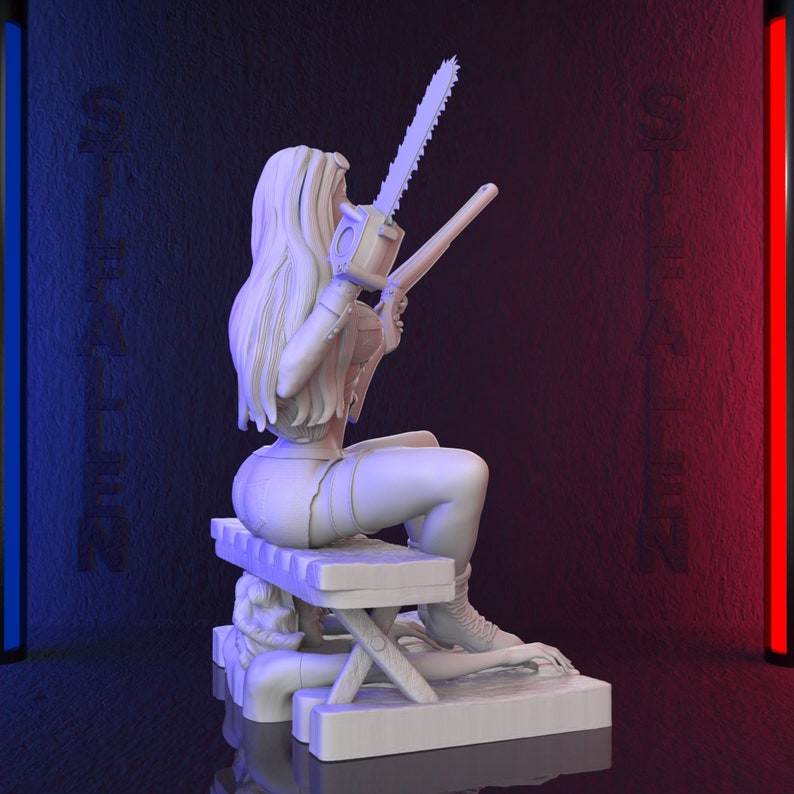 May include: A white 3D-printed figurine of a woman holding a chainsaw and a gun, seated on a bench. The figurine is on a rectangular base. The background is dark with blue and red vertical light bars and the word "ST FALLEN" on the walls.