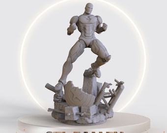 May include: A gray 3D printed figurine of Iron Man standing on a broken base with a broken Captain America shield. The base is surrounded by debris. The text "STL FALLEN" is printed below the figurine.