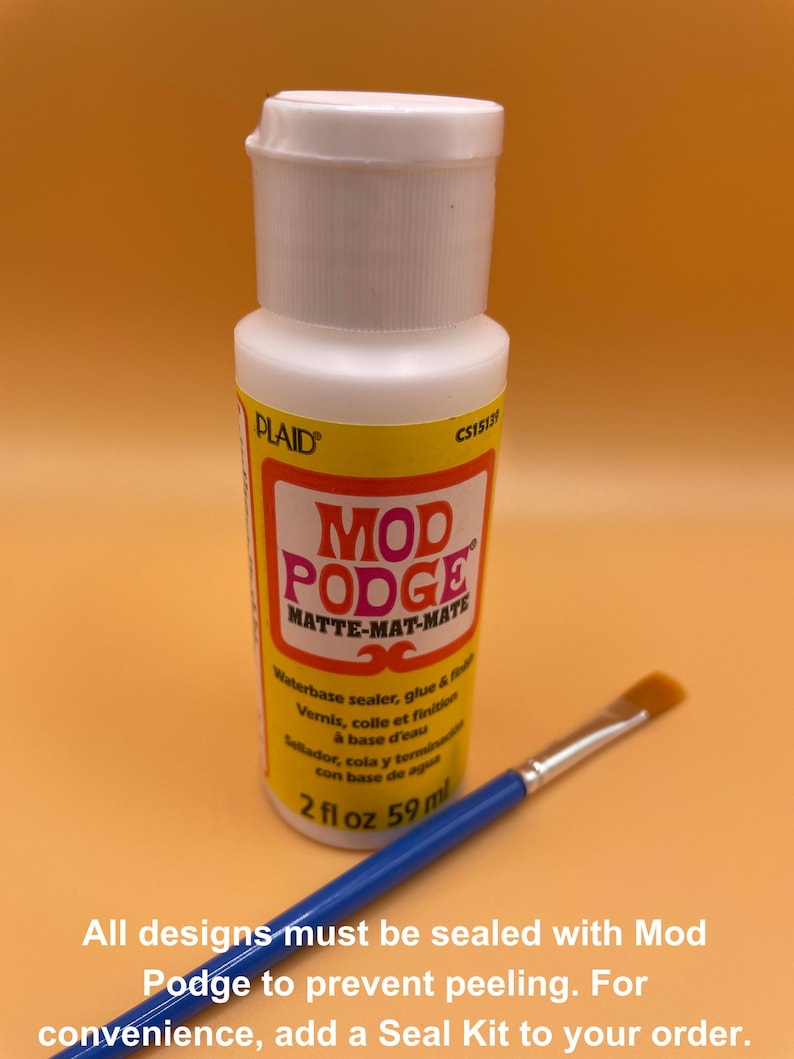 May include: A white bottle of Mod Podge Matte-Mat-Mate sealant with a blue brush. The bottle label says "Waterbase sealer, glue & finish" and "2 fl oz 59 ml".