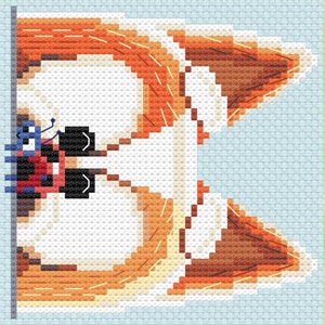 Peut inclure: Motif de point de croix représentant une tête de renard stylisée. Le renard est réalisé dans des tons orange, marron et blanc, avec une figurine insectoïde bleue et rouge près de l'œil. Le fond est bleu clair, avec une bordure verte de style aquarelle.