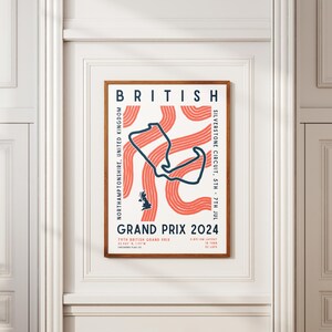 May include: A poster with a white background and a brown frame. The poster features a stylized illustration of the Silverstone Circuit race track in red and blue. The text "BRITISH GRAND PRIX 2024" is printed in bold, black letters. The text "NORTHAMPTONSHIRE, UNITED KINGDOM" is printed in smaller, black letters. The text "SILVERSTONE CIRCUIT - 5TH - 7TH JUL" is printed in smaller, black letters.