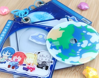 May include: A collection of anime-themed CD cases and a CD. The cases are blue with cartoon illustrations of a band and a spaceship. The CD has a planet design with green continents and blue oceans. A blue lanyard is attached.