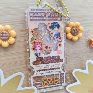 Kare Kano-sleutelhanger: acrylbedel met lovertjes en zonnebloemaccessoire