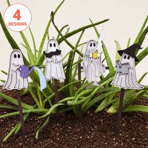 May include: Four ghost-shaped plant markers on dark brown stakes. One ghost holds a purple watering can, one holds a black cat, one holds a yellow mug with steam, and one wears a black witch hat while reading a book. A circle says 4 DESIGNS.