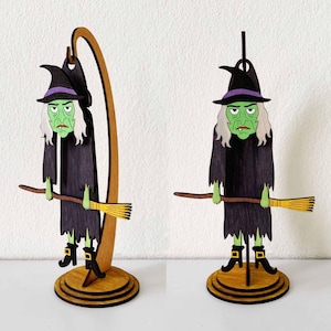 May include: Wooden witch figurine with a green face, black hat with purple band, and black dress. The witch holds a broom and stands on a wooden base. The figurine is designed for Halloween decorations.