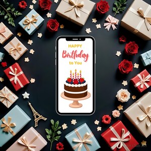 Digital birthday e-card mockup with chocolate cake on phone, surrounded by wrapped presents, roses, and festive decorations on a black surface