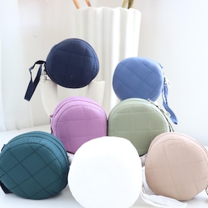 May include: Seven round quilted zippered pouches in various colors, including navy blue, light blue, purple, green, beige, white, and dark green.