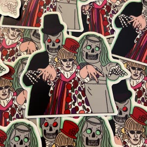 May include: A sticker depicting three figures with skull faces. One wears a top hat and suit, another a red hat, and the third a veil. The figures are surrounded by similar stickers.