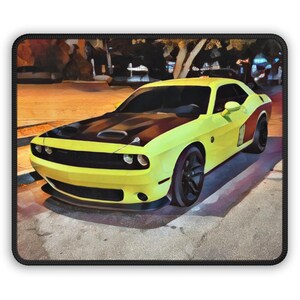 May include: Yellow and black sports car mousepad. The car has a black hood and black wheels. The car has a red stripe on the side. The background is a blurred image of a street at night.