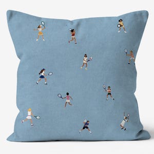 Puede incluir: Un cojín cuadrado con fondo azul claro que presenta un patrón repetitivo de pequeñas figuras ilustradas jugando al tenis. Cada figura aparece en diversas posturas atléticas, sosteniendo una raqueta de tenis y vistiendo diferentes conjuntos.