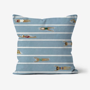 May include: Square throw pillow with a blue background and white horizontal stripes. The pillow features a pattern of swimmers in various swimsuits, positioned as if swimming in lanes.