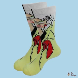 Könnte beinhalten: Ein Paar gelbe und weiße Socken mit einem Cartoon-Bild einer Frau, die einen gelben Mantel und rote Handschuhe trägt. Die Frau hat weißes Haar und einen überraschten Ausdruck.
