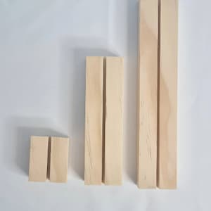 May include: Three wooden display stands of varying sizes. Each stand has two vertical slots cut into the front.