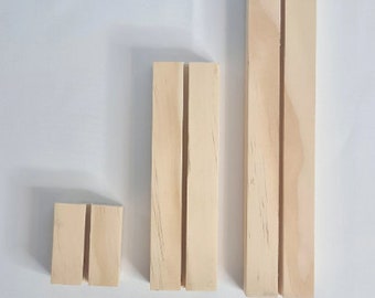 May include: Three wooden display stands of varying sizes. Each stand has two vertical slots cut into the front.