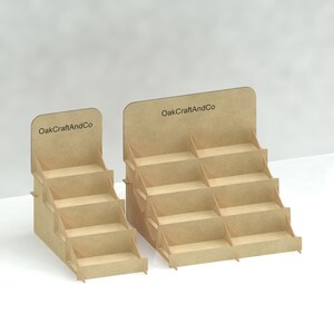 May include: Two wooden display stands with the text "OakCraftAndCo" printed on the front. The larger stand has six shelves and the smaller stand has four shelves.