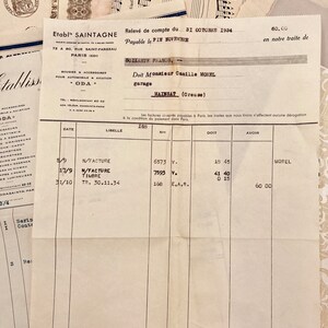 May include: A vintage invoice from Etabl' Saintagne, a company that sold car parts and accessories, dated October 31, 1934. The invoice is for a customer named Monsieur Camille Morel, who owns a garage in the town of Mailsat, Creuse, France. The invoice lists three items: N/Facture, N/Facture Timbre, and TR. 30.11.34. The total amount due is 60.00 francs.
