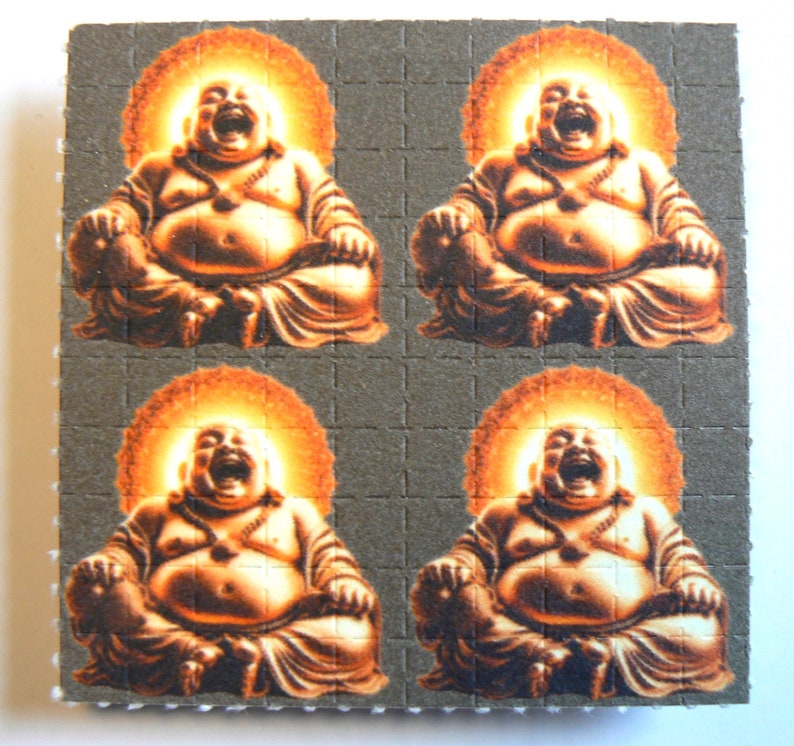 May include: Four images of a laughing Buddha, each with a halo of light, sitting in a meditative pose with hands in their lap. The background is a gray, textured surface.