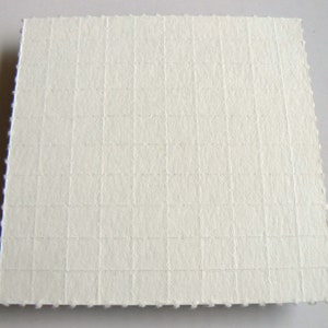 May include: White textured paper with a grid pattern.