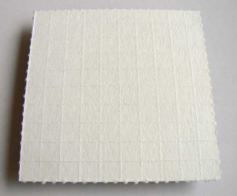 May include: White textured paper with a grid pattern.