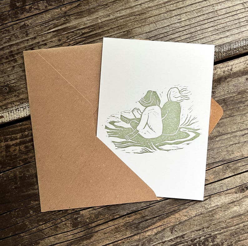 May include: A green linocut print of two people sitting back to back on a grassy hill.